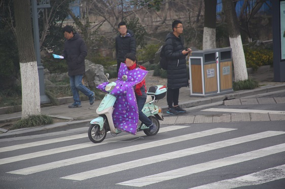 Mopedfahrerin im Winter in Südchina